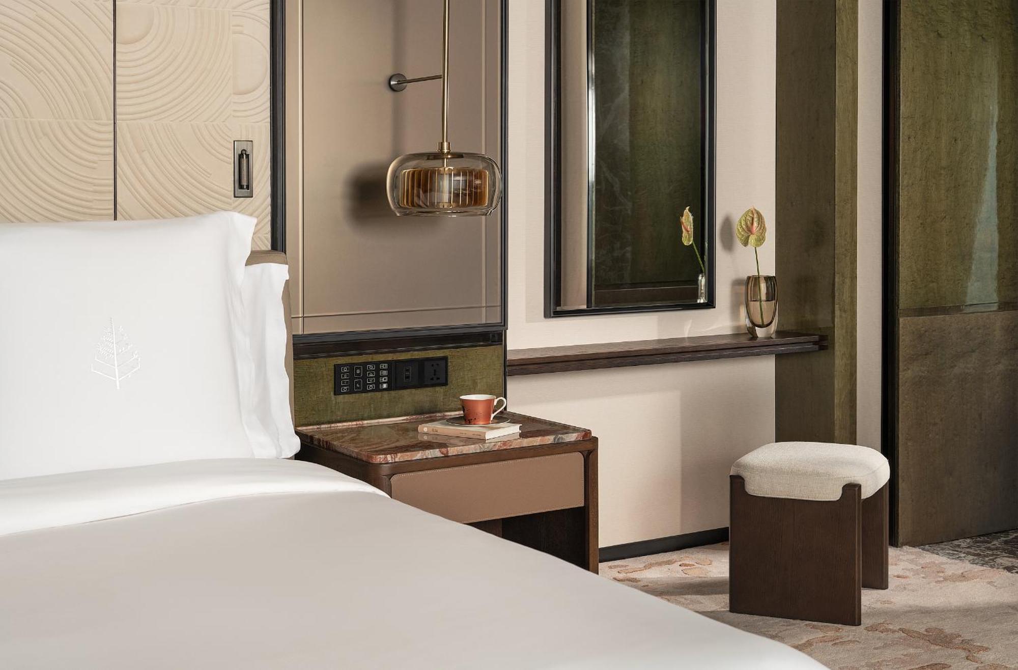 Kamer met kingsize bed, bad aan het raam en uitzicht op de skyline van de stad